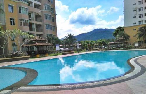 a large blue swimming pool in the middle of a building at Chomey Homestay in Mantin