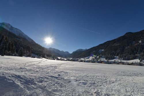 a snow covered field with the sun in the background at Apartmenthaus Mountainvista in Kleinarl