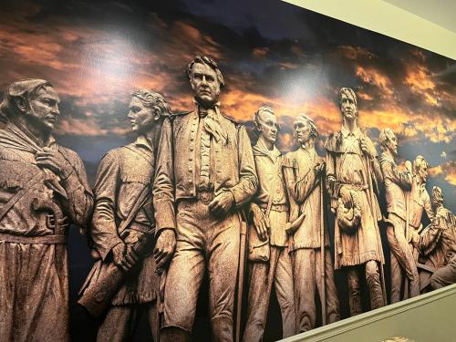 a statue of a group of people on a wall at The Crockett Hotel in San Antonio