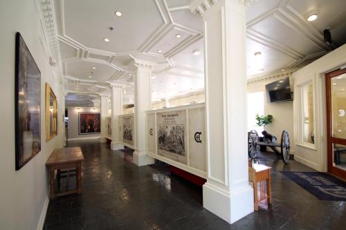 a hallway of a museum with columns and paintings at The Crockett Hotel in San Antonio