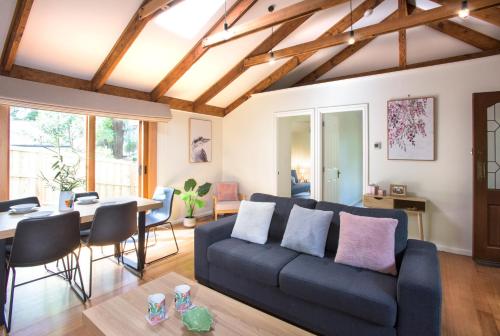 a living room with a blue couch and a table at Cosy, central Olinda Camellia Cottage in Olinda
