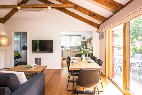 a living room with a table and a couch at Cosy, central Olinda Camellia Cottage in Olinda