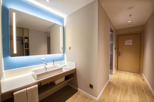 a bathroom with a sink and a mirror at Holiday Inn Express Tianjin Binhai by IHG in Binhai