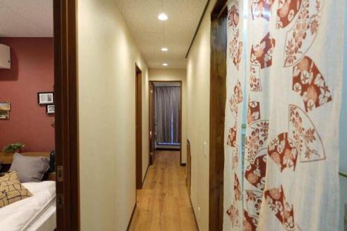 東京にあるAN HOTELのベッド付きの部屋と廊下のサイドシックスへと続く廊下