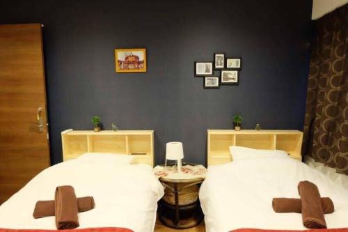 東京にあるAN HOTELのベッドルーム1室(茶色の十字架が付いたベッド2台付)