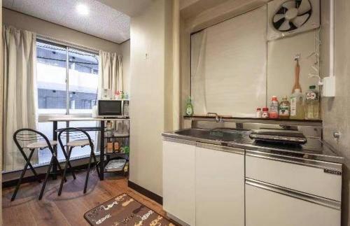 東京的住宿－AN HOTEL，厨房配有柜台和桌椅