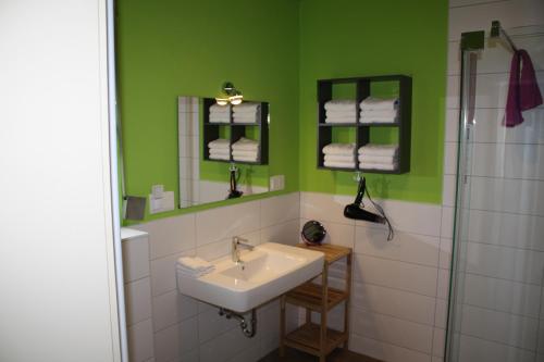 uma casa de banho com um lavatório e uma parede verde em Holiday home Paula em Neunkirchen