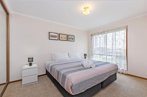 菲利港的住宿－Fauxs Den，一间卧室设有一张大床和一个窗户。
