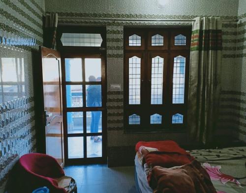 a bedroom with windows and a bed in a room at Devbhoomi by StayApart in Ukhimath