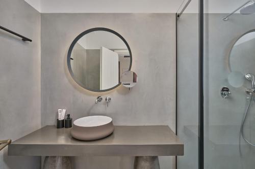 ein Bad mit einem Waschbecken und einem Spiegel in der Unterkunft Voya Sifnos Mindful Stay in Kamarai