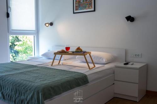 a bedroom with a bed with a table on it at Pansion Hukić B&B in Tuzla