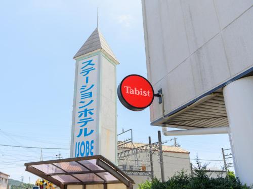 un panneau indiquant un bâtiment avec un panneau indiquant un hôtel dans l'établissement Tabist Station Hotel Isobe Ise-Shima, à Shima