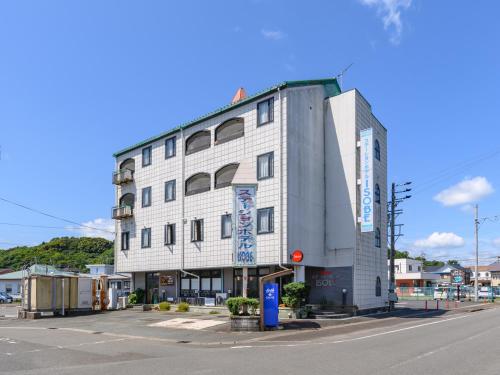 un grand bâtiment blanc au coin d'une rue dans l'établissement Tabist Station Hotel Isobe Ise-Shima, à Shima