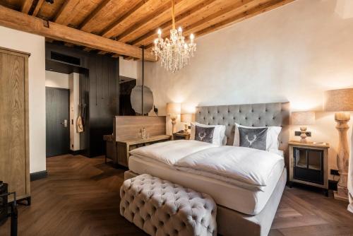 una camera da letto con un letto grande e un lampadario di Boutiquehotel Weisses Rössl a Innsbruck