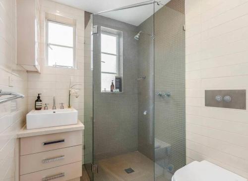 a bathroom with a glass shower and a sink at East Melbourne 1BR - Close to the MCG in Melbourne