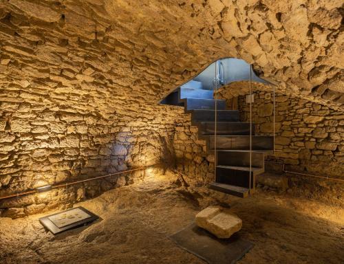 - un escalier dans une grotte avec un mur en pierre dans l'établissement Gîte Des Caves Secrètes, à Tiffauges