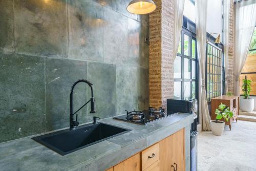 a kitchen with a sink and a stove at Villa Upeksha - Huge 1-bedroom Villa with pool in Pererenan in Munggu