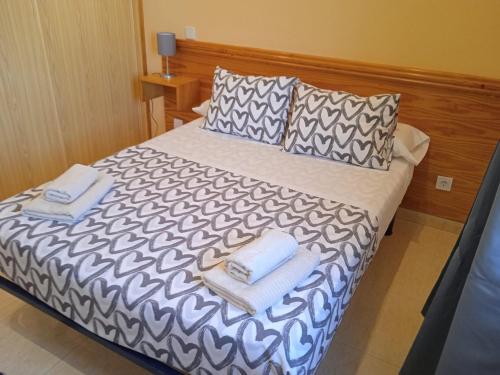 a bedroom with a bed with towels on it at HOTEL El ALAMO MADRID in El Álamo