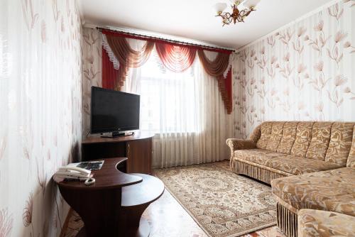 a living room with a couch and a television at Гостиница Караганда in Karagandy
