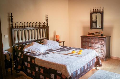 a bedroom with a bed with a dresser and a mirror at Casarao dos Reis in Caravela