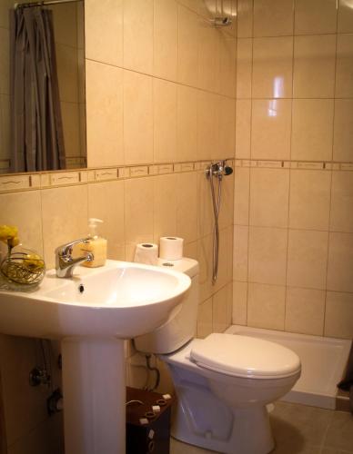 a bathroom with a sink and a toilet and a mirror at Casarao dos Reis in Caravela