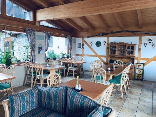 un restaurante con techos de madera, mesas y sillas en Romantik Appartements, en Sankt Englmar