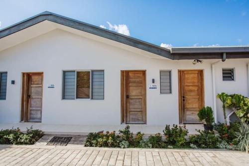 a white house with wooden doors and a courtyard at Platinum Cawa Apartments in Nadi