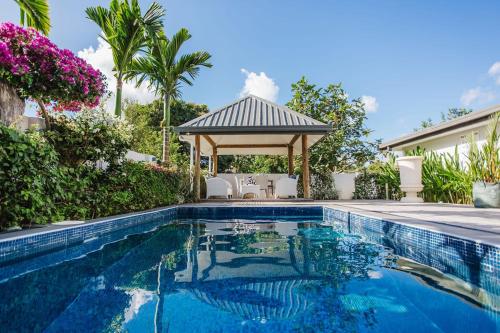 a swimming pool with a gazebo next to a house at Platinum Cawa Apartments in Nadi