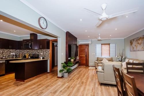 Platinum Cawa Apartments في نادي: مطبخ وغرفة معيشة مع ساعة على السقف
