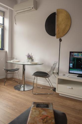 a living room with a table and a chair and a laptop at Iassium Residence Iasi in Iaşi