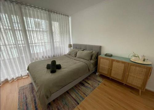 a bedroom with a bed and a large window at South Melbourne Central 1BR - 106 in Melbourne
