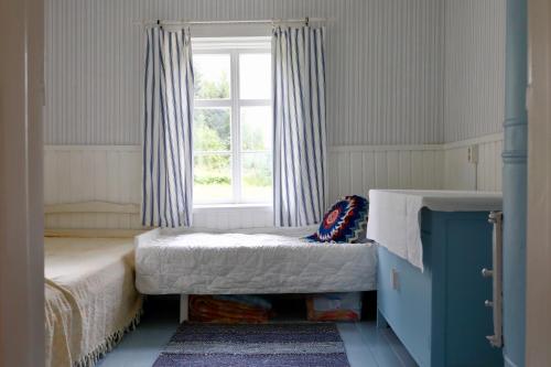 Un dormitorio pequeño con una cama y una ventana. en Ylatupa, en Kesälahti