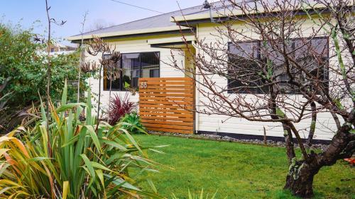 a white house with a fence in a yard at Room @ 88 in Devonport