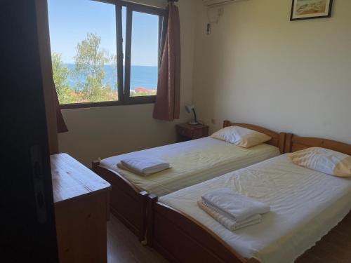 twee eenpersoonsbedden in een kamer met een raam bij Complex Terazini in Byala