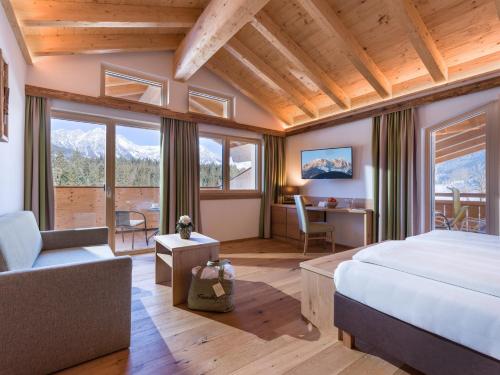 a bedroom with a bed and a desk in a room with windows at Franzlhof in Söll