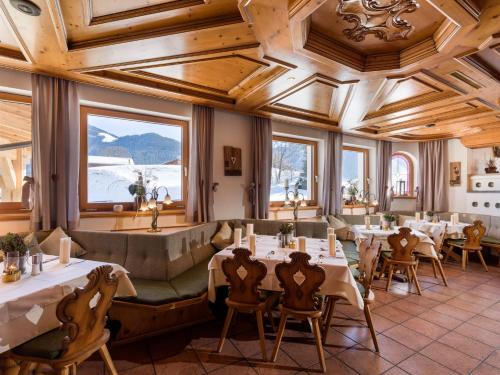 a restaurant with tables and chairs and windows at Franzlhof in Söll