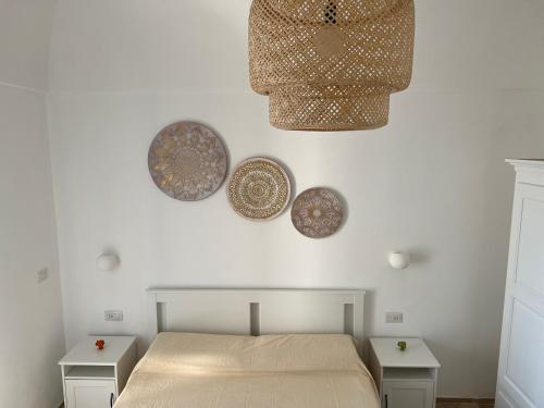 セルヴァ・ディ・ファザーノにあるNinetta Houseのベッドルーム1室(ベッド1台、壁に3皿)