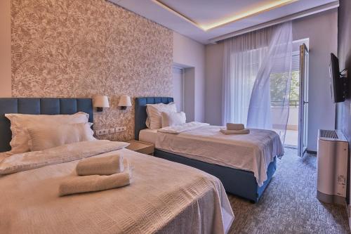 Cette chambre comprend 2 lits et une fenêtre. dans l'établissement Cataleya, à Šabac