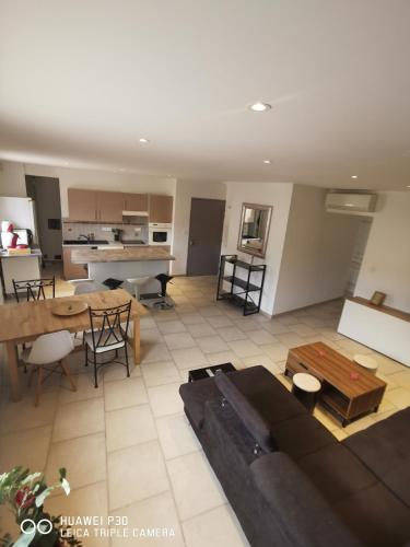 un salon avec un canapé et une table dans l'établissement résidence l'Olivier, à Forcalqueiret