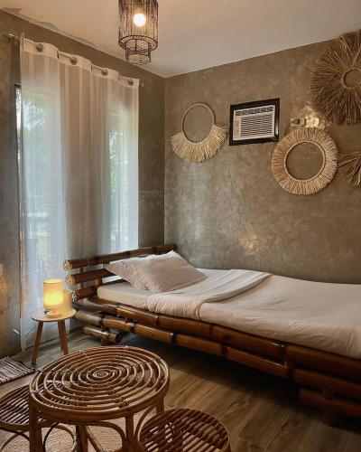 a bedroom with two beds and a table and mirrors at Your Brothers House Tribal Village in Legazpi
