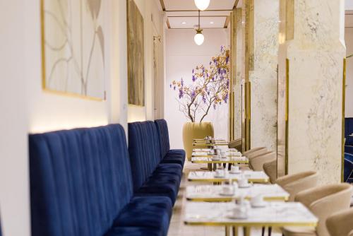 a row of tables in a restaurant with blue chairs at Grandhotel Pupp in Karlovy Vary