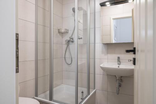 uma casa de banho com um chuveiro e um lavatório. em JOHOUSE Apartment 3 em Warnemünde