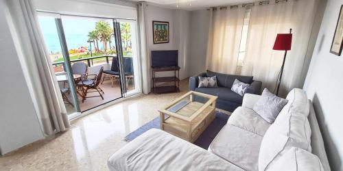 un soggiorno con divano e TV di SEAVIEW y BEACH 1 línea Vistas al Mar Renovado a Fuengirola
