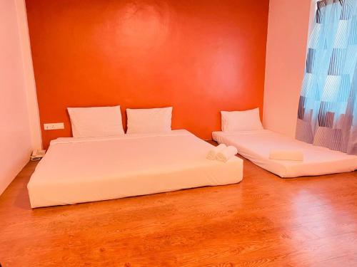 a bedroom with two beds and a window at Orange Hotel Segamat in Segamat