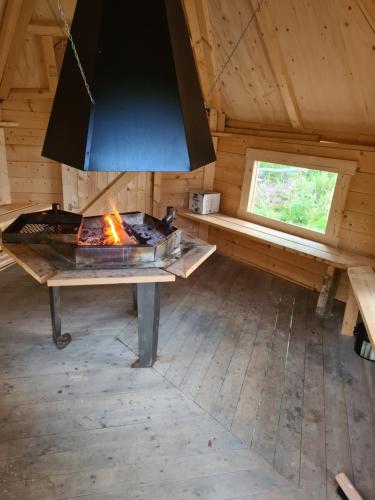 a fireplace in a log cabin with a stove at House with private beach in Rautalampi