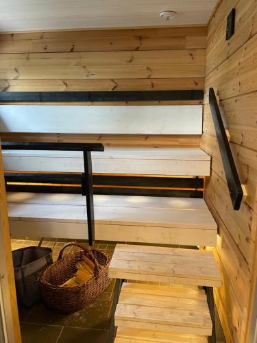 a wooden sauna with a bench and a basket at Hideway Glamping Tree tent in Muurame