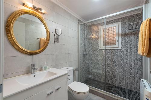 Un baño con inodoro, lavabo y espejo. en Apartment Scandi - Alcúdia, en Alcudia