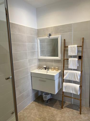 une salle de bain avec un lavabo, un miroir et des serviettes dans l'établissement Les Jardins De Santa Giulia - Charmante chambre dhte, à Porto-Vecchio