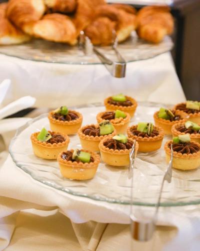 a plate of mini pies on a table with pastries at Hotel Polo in Rimini