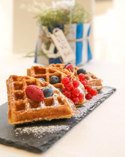a plate with two waffles with berries on it at Hotel Polo in Rimini